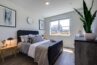 Modern bedroom in an apartment with a double bed, stylish decor, and a large window offering a view.