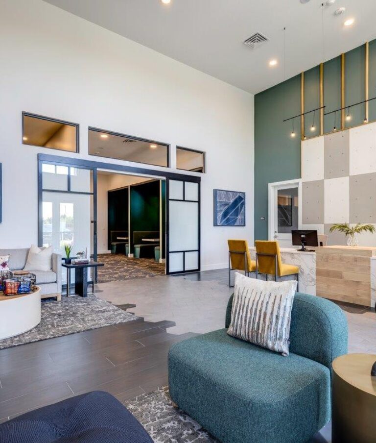 Modern apartment community space with seating area and a reception desk.