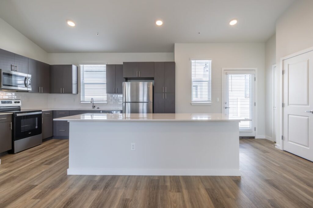 Modern kitchen in an apartment with stainless steel appliances and dark cabinets.