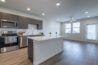 Modern apartment kitchen with stainless steel appliances and a central island.